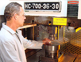 Worker operating HC-700 impact extrusion machine